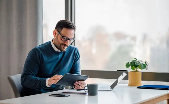 Male executive using tablet at work desk