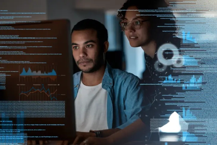 Colleagues writing code on a computer in AI tech office